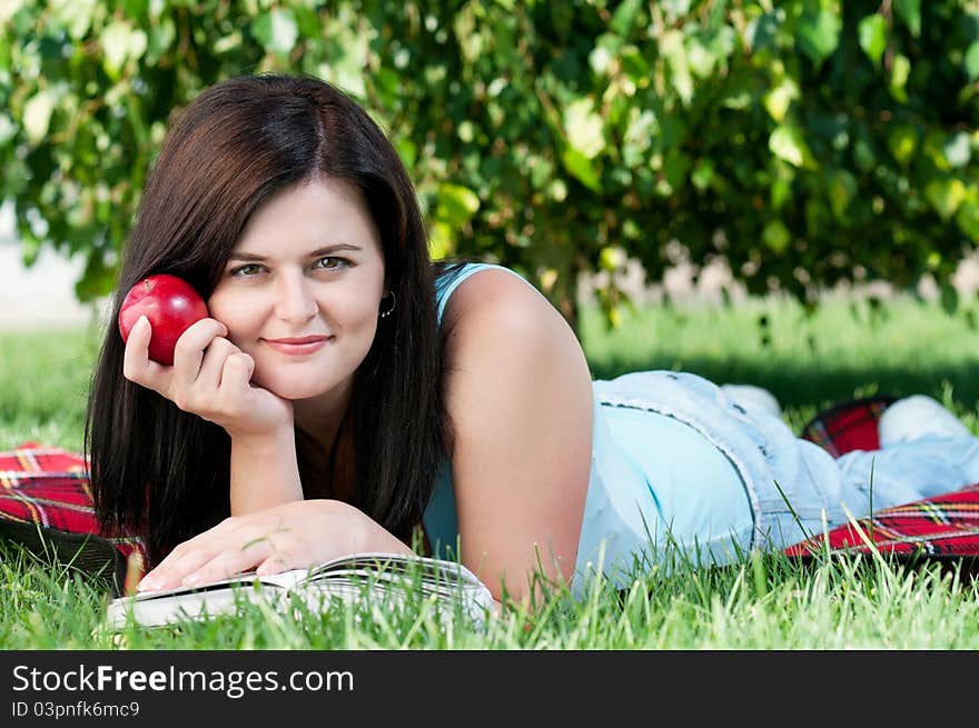 Portrait of a young female student with book at the campus