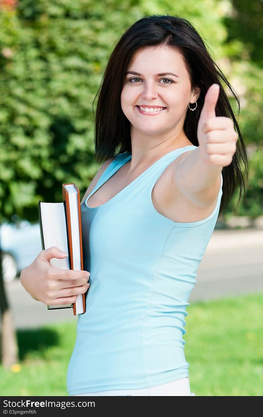 Portrait of a young female student with books at the campus