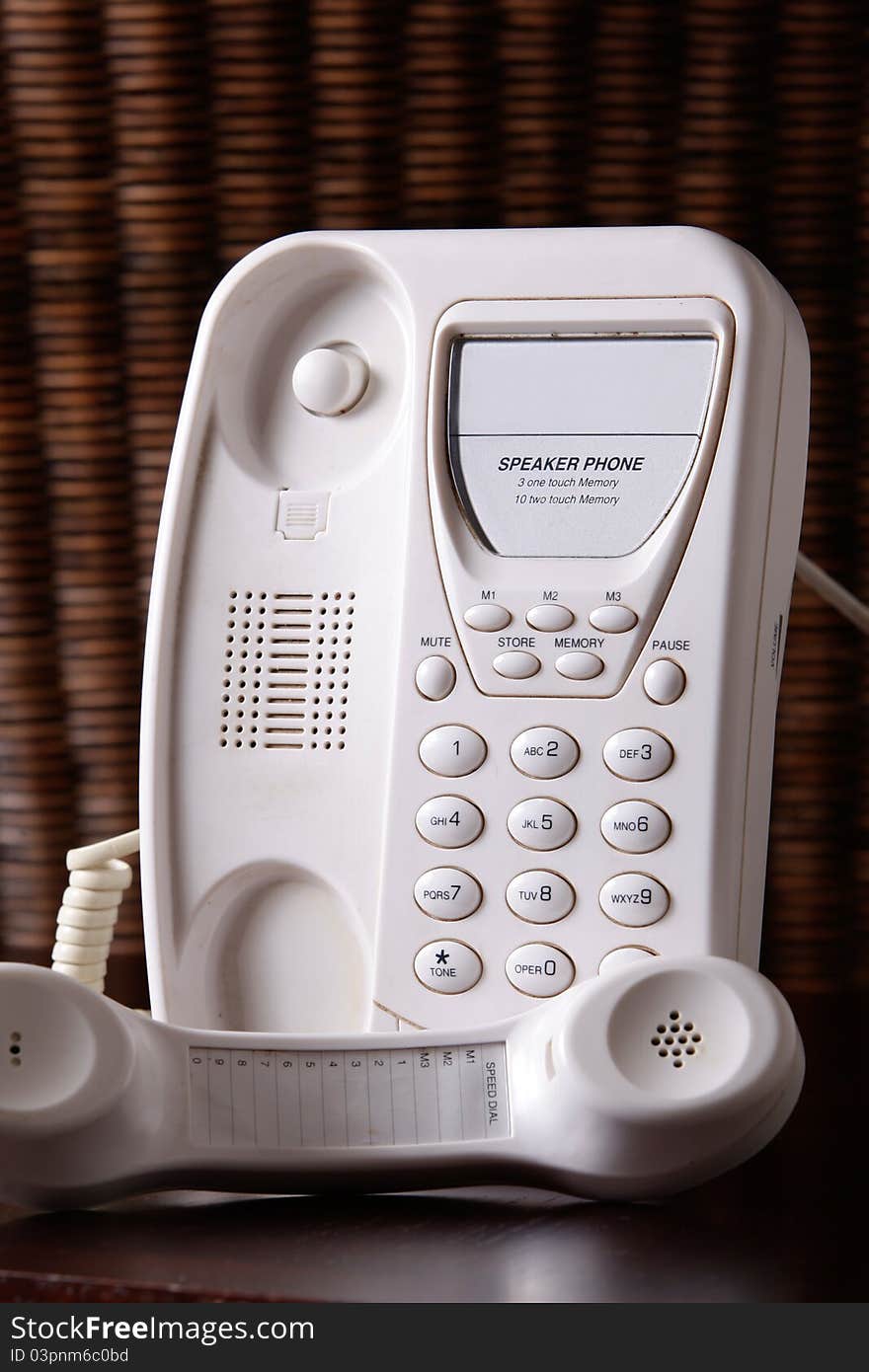 A white telephone with the earpiece off the hook