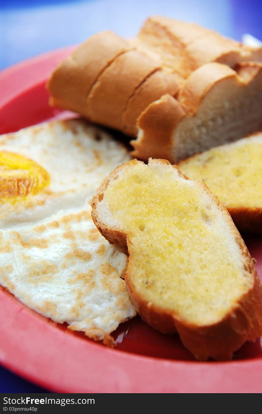 A garlic bread and fry egg served on table. A garlic bread and fry egg served on table.