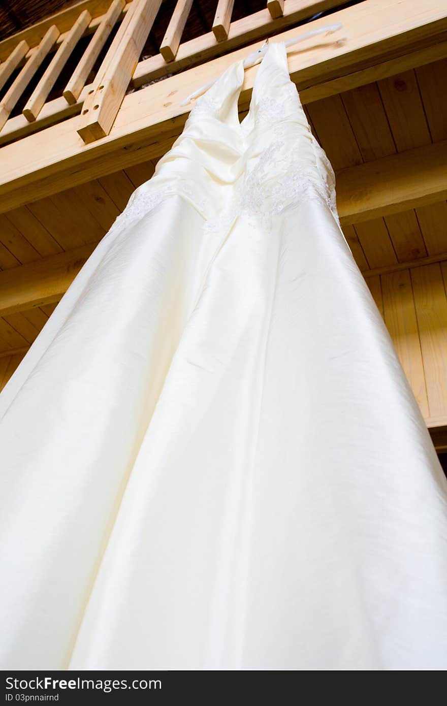 A hanging wedding dress photographed from below