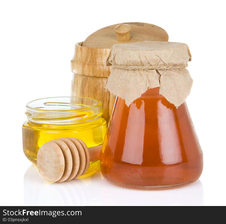 Glass jar full of honey and stick on white background