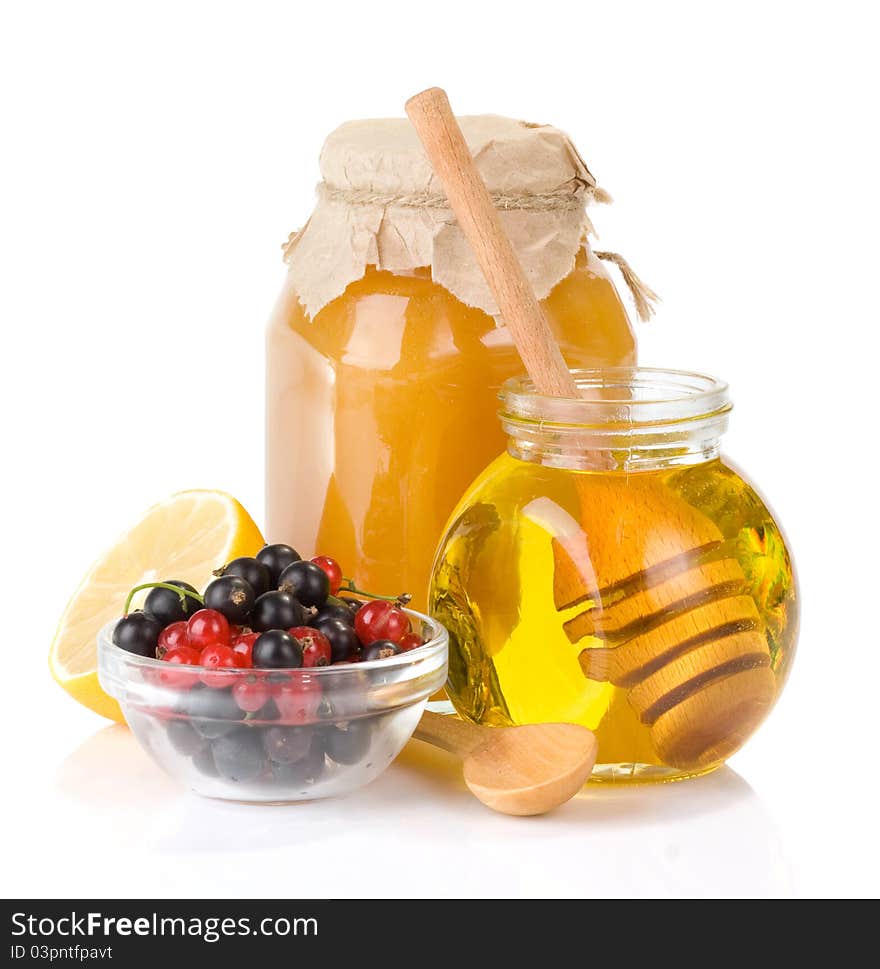 Glass jar full of honey and berry on white background