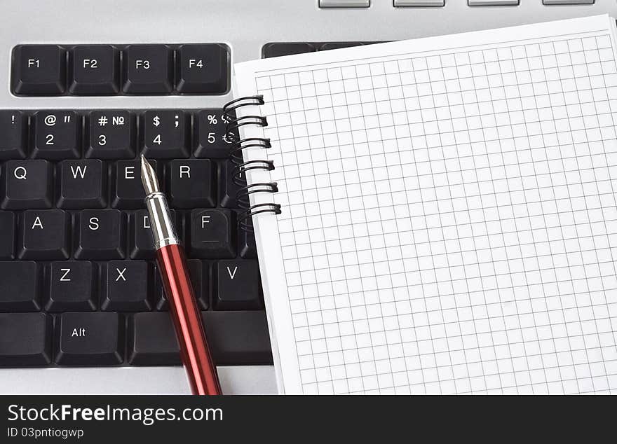 Computer keyboard and pen with notebook