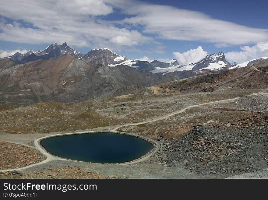 The Pennine Alps scenery represented by the glacier lake in the forefront and the pinnacles of Pennine Alps such as Dom or Taschhorn.