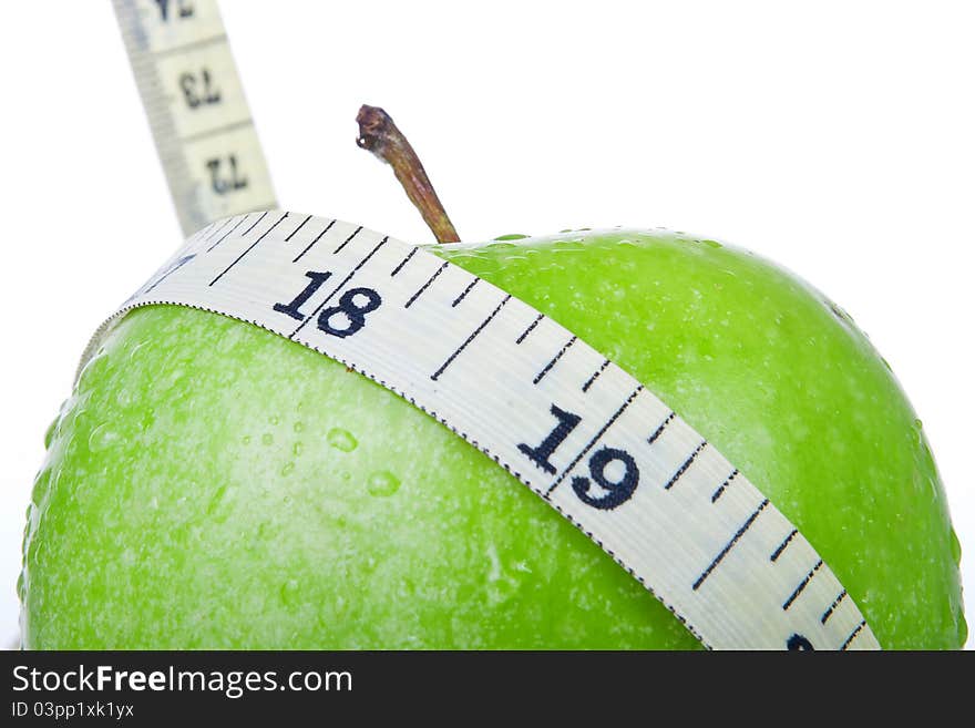 Green apple with tape measure isolated on white background