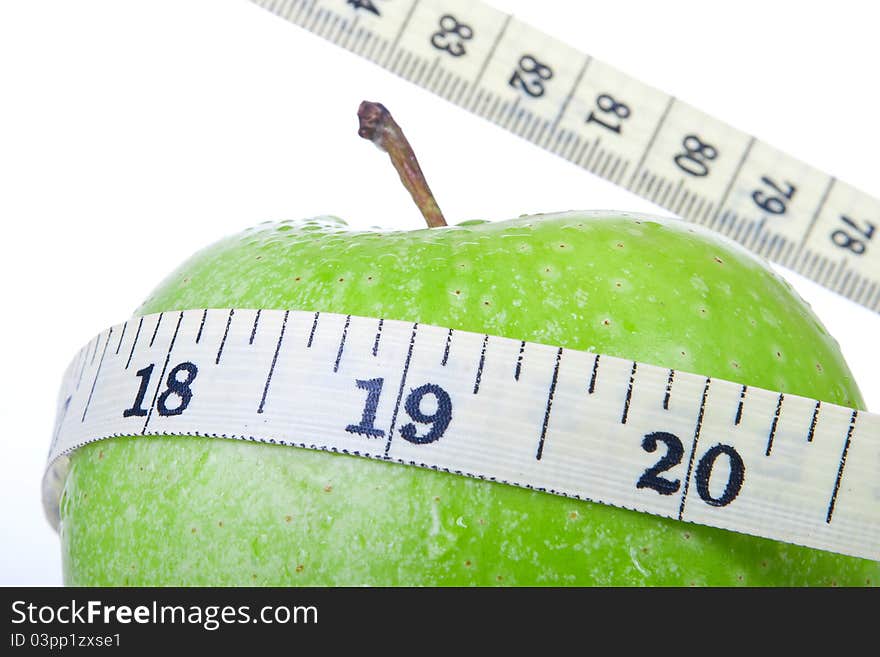 Green apple with tape measure isolated on white background