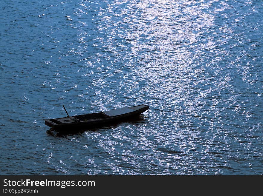 A wood boat lay at anchor in the bay。