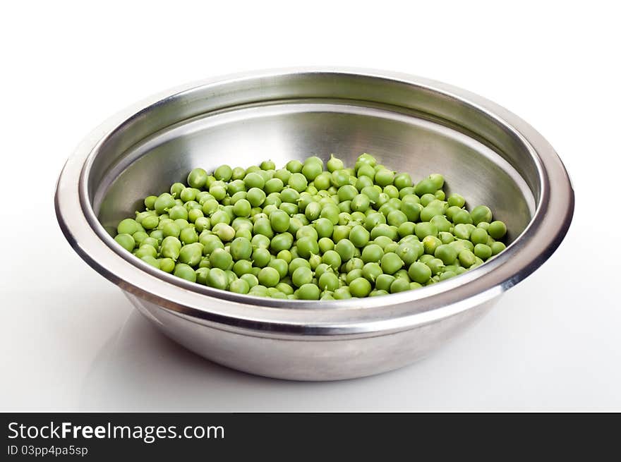 Fresh green peas in a metal plate isolated on a white background