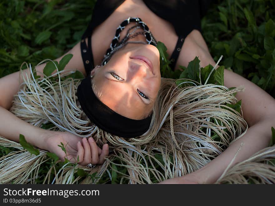 Young woman with braided lies on the grass