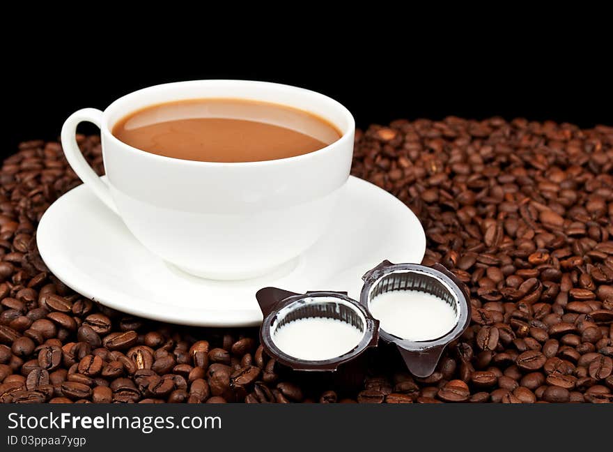 Coffee with milk and coffee beans on a black background. Coffee with milk and coffee beans on a black background