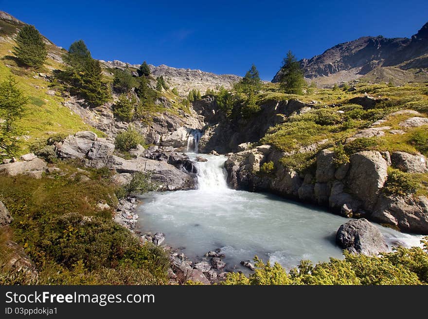 Waterfall and lake in Rutor mountain, Val d'Aosta, Italy