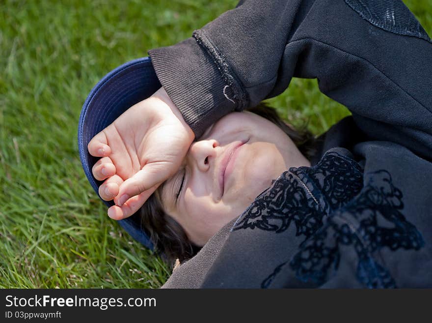 Boy laying down on grass relaxing in the sun. Boy laying down on grass relaxing in the sun.