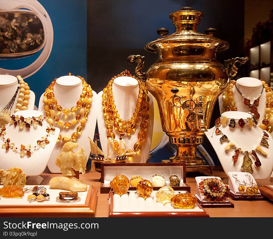 The big gold samovar and ornaments from amber in a bright show-window of gift shop in Moscow on Arbat. The big gold samovar and ornaments from amber in a bright show-window of gift shop in Moscow on Arbat