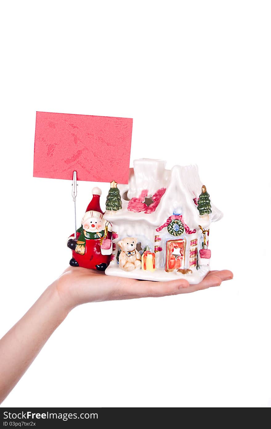 Hand holding toy house and snowman with business card over white. Hand holding toy house and snowman with business card over white