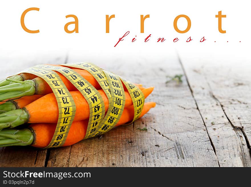 Fresh carrots with measure tape around, diet concept, place for your text up