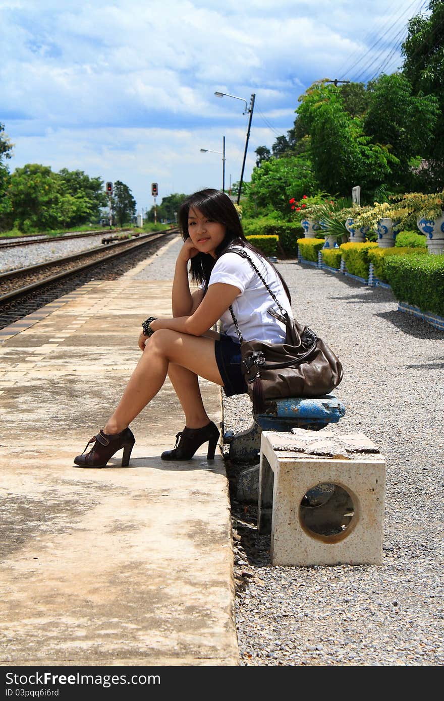 Young traveling woman with her suitcases on the railway tracks. Young traveling woman with her suitcases on the railway tracks