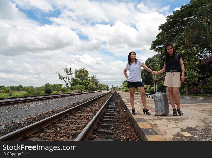 Young traveling women with her suitcases on the railway tracks. Young traveling women with her suitcases on the railway tracks