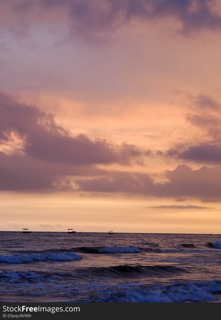 Image of exotic sky over sea at sunset. Increasing waves reflects sunlight with clouds. Image of exotic sky over sea at sunset. Increasing waves reflects sunlight with clouds.