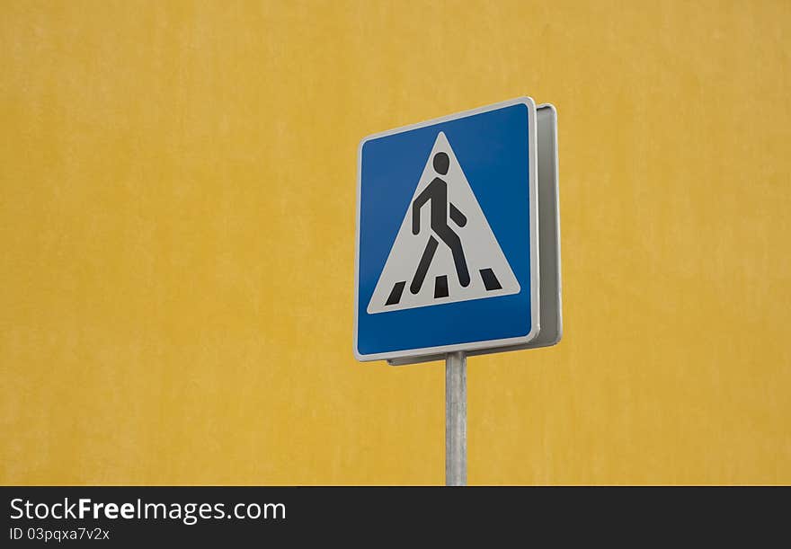 Crosswalk road sign on yellow background