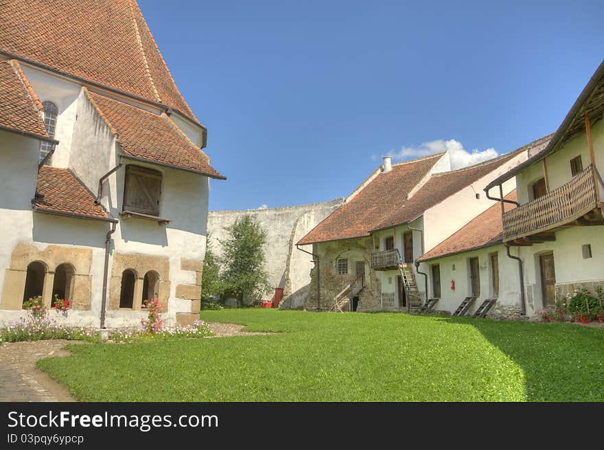 Interior courtyard of the fortified church of Harman in rural Romania. Old houses inside a small stronghold. Interior courtyard of the fortified church of Harman in rural Romania. Old houses inside a small stronghold