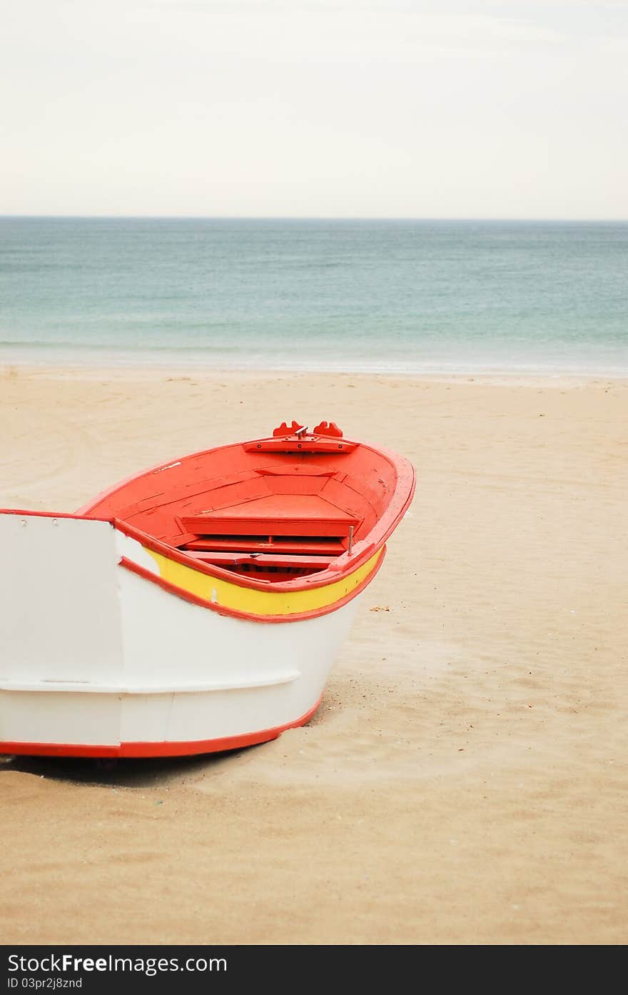 Bright painted small fishing boat in the beach