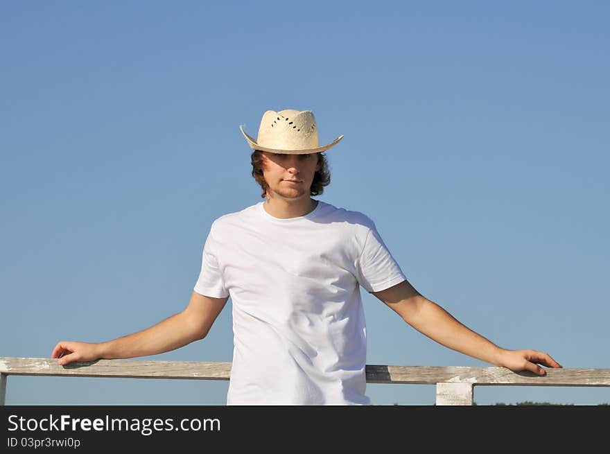 Young man straw hat against blue sky. Young man straw hat against blue sky