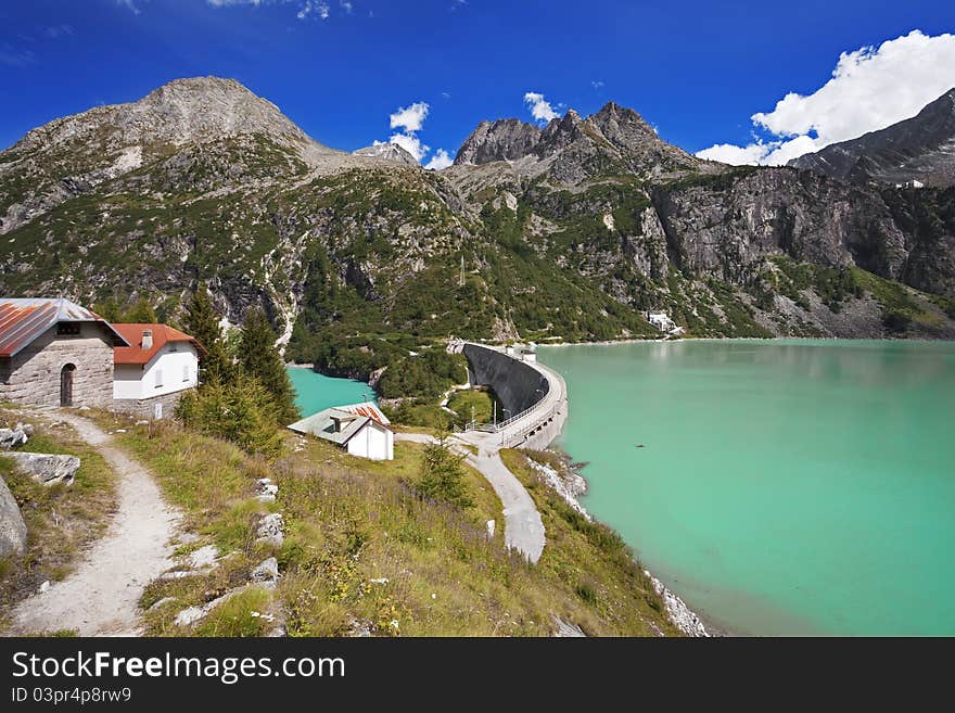 Dam and man-made lake between mountains. It’s Avio Lake, North of Italy, Lombardy region, at 1.923 meters on the sea-level. Dam and man-made lake between mountains. It’s Avio Lake, North of Italy, Lombardy region, at 1.923 meters on the sea-level