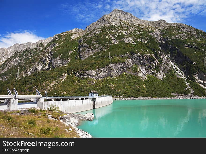 Dam and man-made lake between mountains. It’s Avio Lake, North of Italy, Lombardy region, at 1.923 meters on the sea-level. Dam and man-made lake between mountains. It’s Avio Lake, North of Italy, Lombardy region, at 1.923 meters on the sea-level