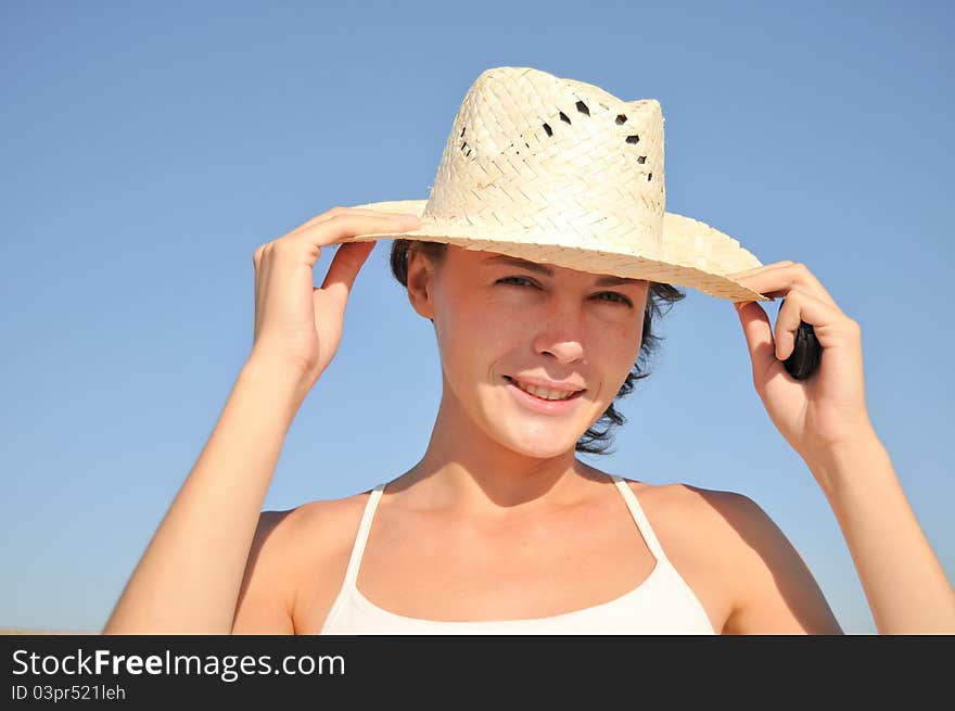 Young woman straw hat against blue sky. Young woman straw hat against blue sky