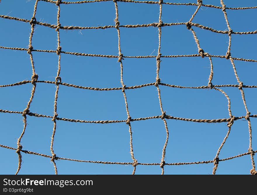 Rope chain with a large hole and the blue sky. Rope chain with a large hole and the blue sky