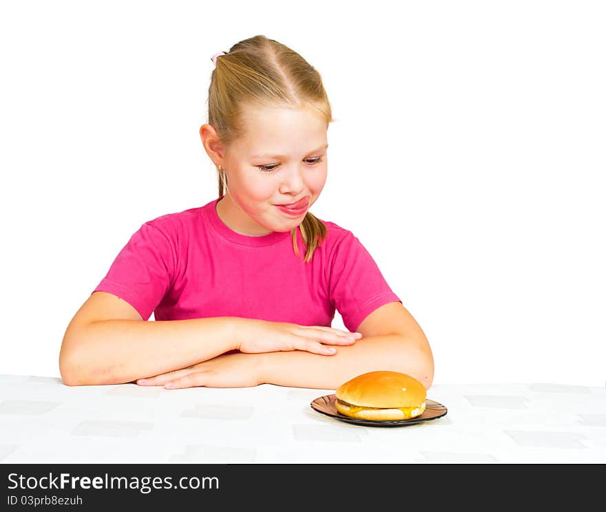 Little girl looking hamburger with tongue out on white