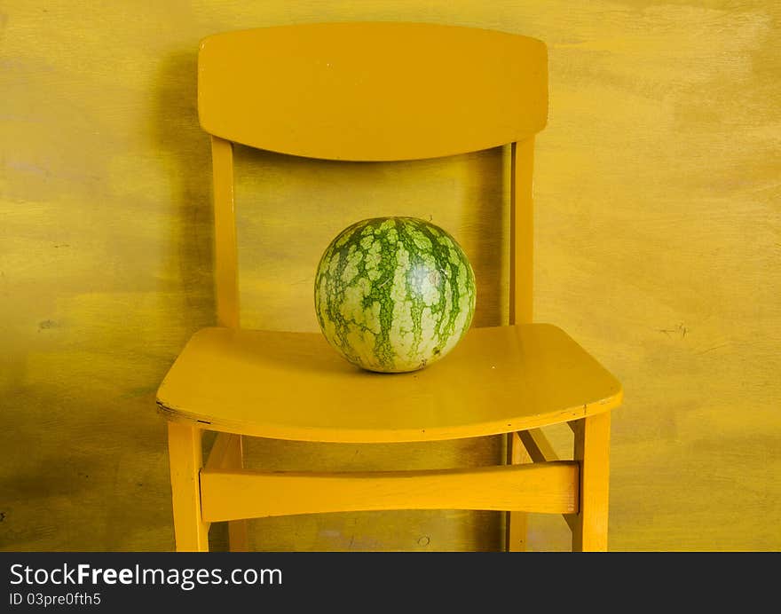 Watermelon on yellow chair and yellow background