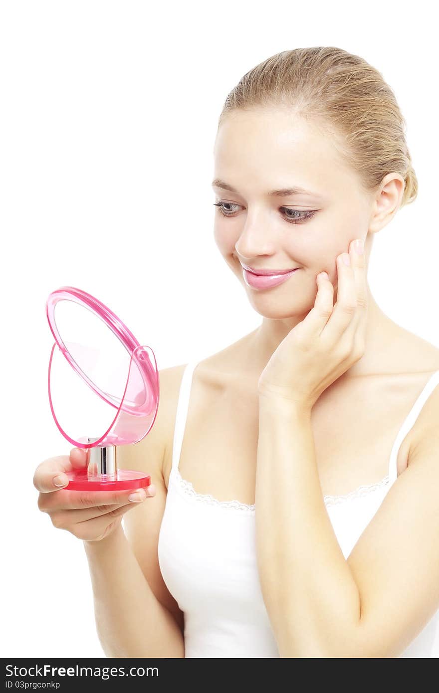 Girl looking into a hand mirror isolated on a white background. Girl looking into a hand mirror isolated on a white background