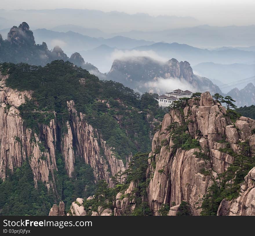 Tele image of Huangshan mountain and Chinese style house at cloudy weather, sunset. Aerial view at Yellow Mountain. China, Asia