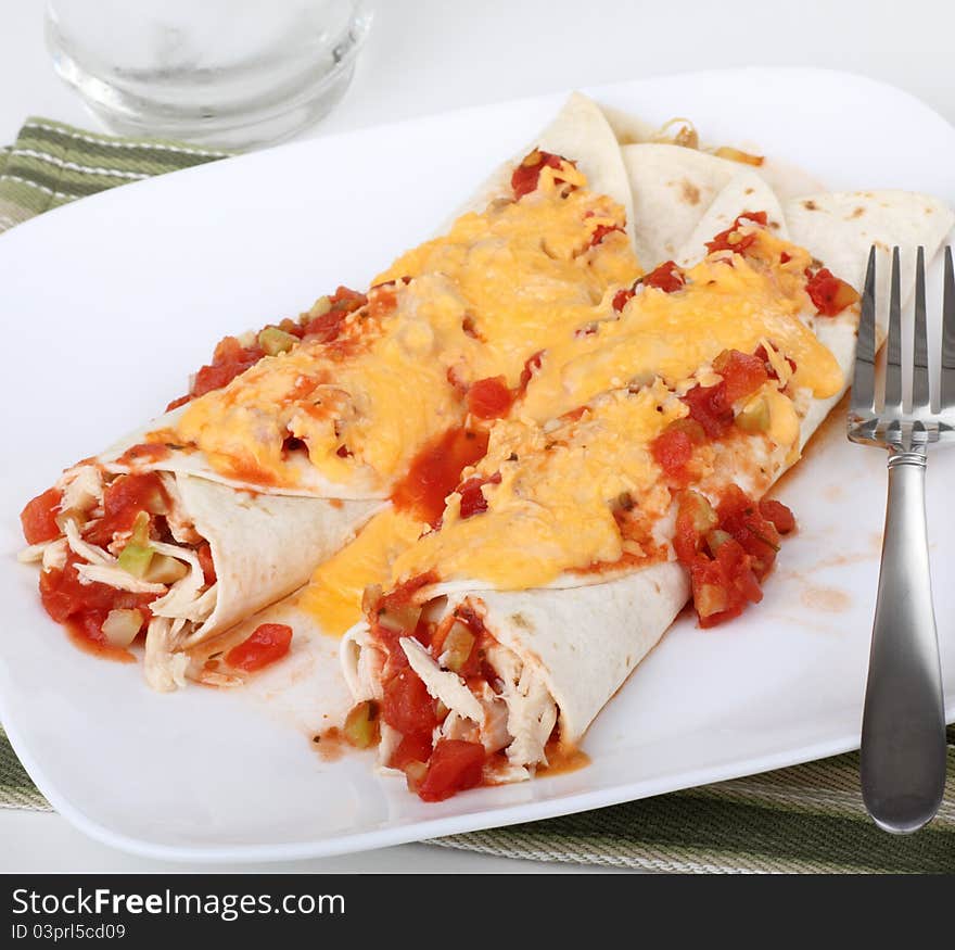 Two chicken fajitas topped with cheese on a plate