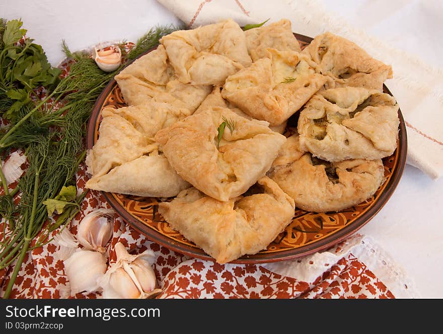 Tasty salty baking with cheese and fennel and with garlic on a dish on a napkin. Tasty salty baking with cheese and fennel and with garlic on a dish on a napkin