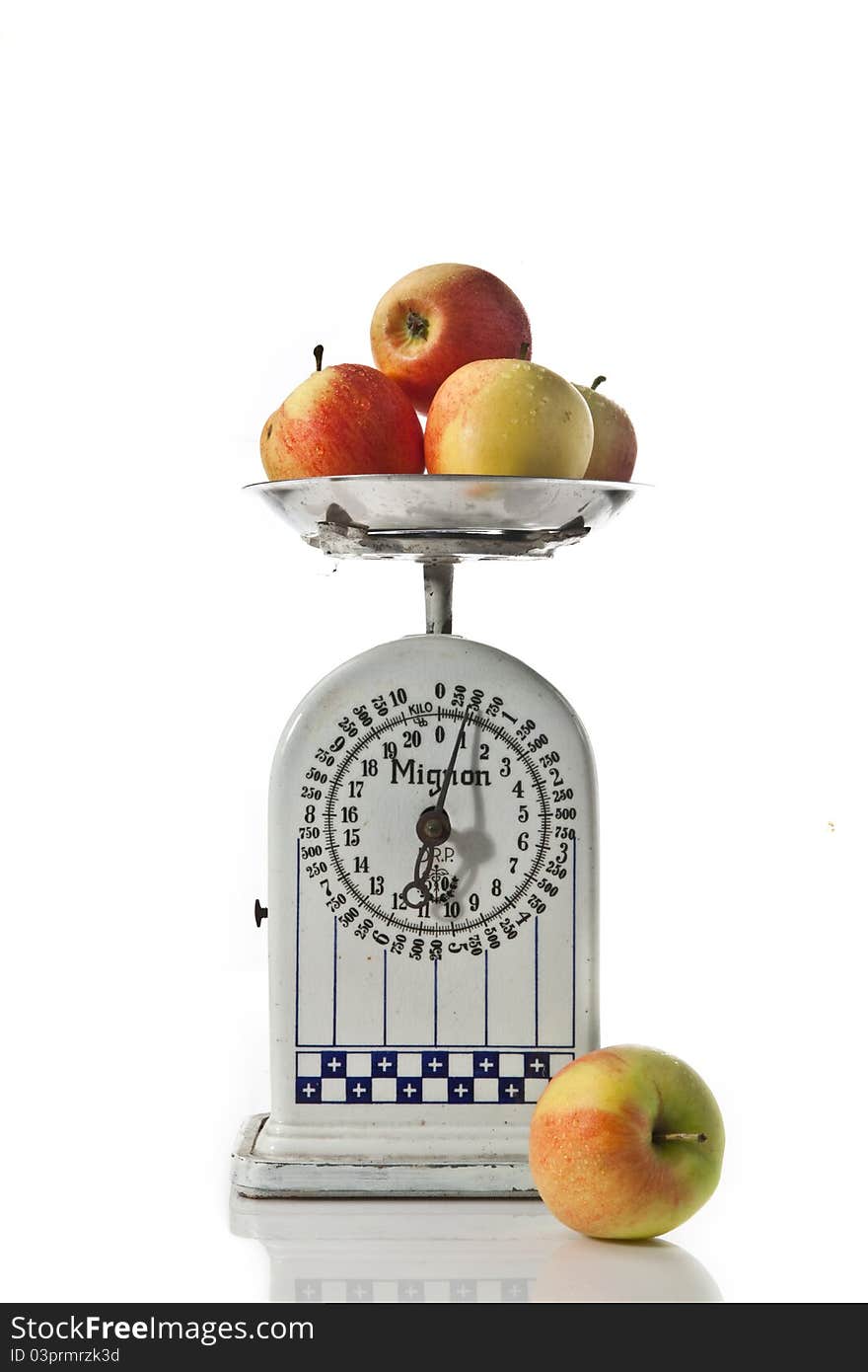 An old scale with fresh apples on white background. An old scale with fresh apples on white background