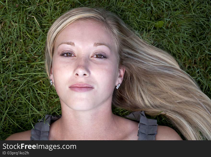 Beautiful young blond model lying on grass. Beautiful young blond model lying on grass