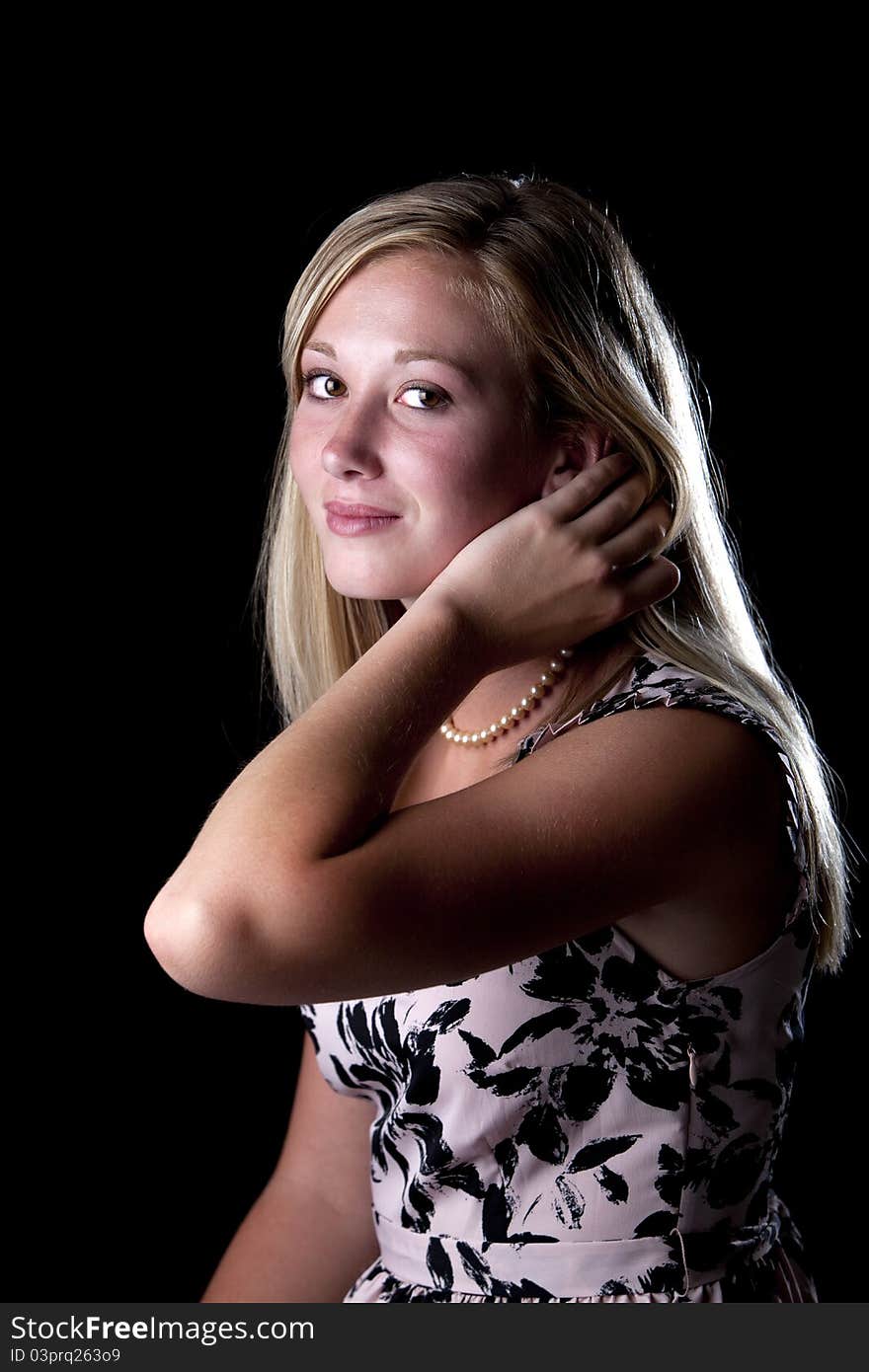 Beautiful young blond model posing in studio against black backdrop. Beautiful young blond model posing in studio against black backdrop