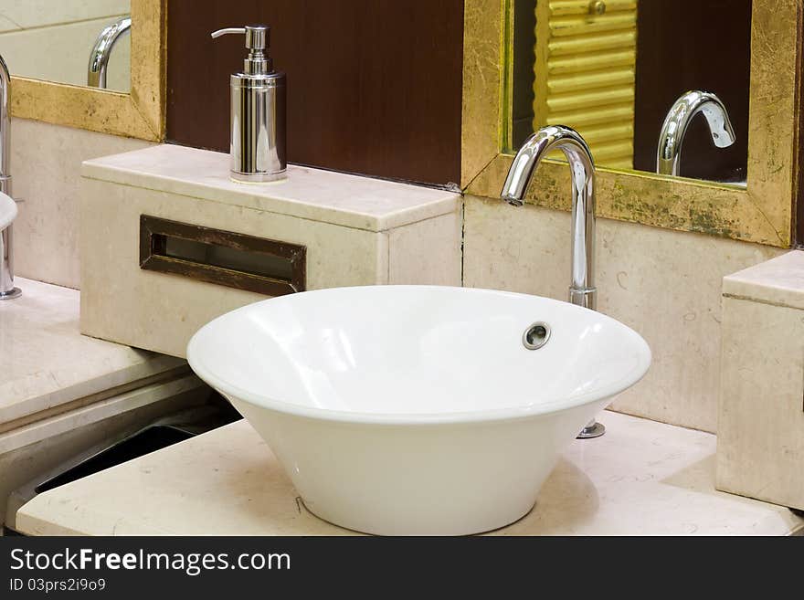 Washbasins, taps and mirror in a public toilet