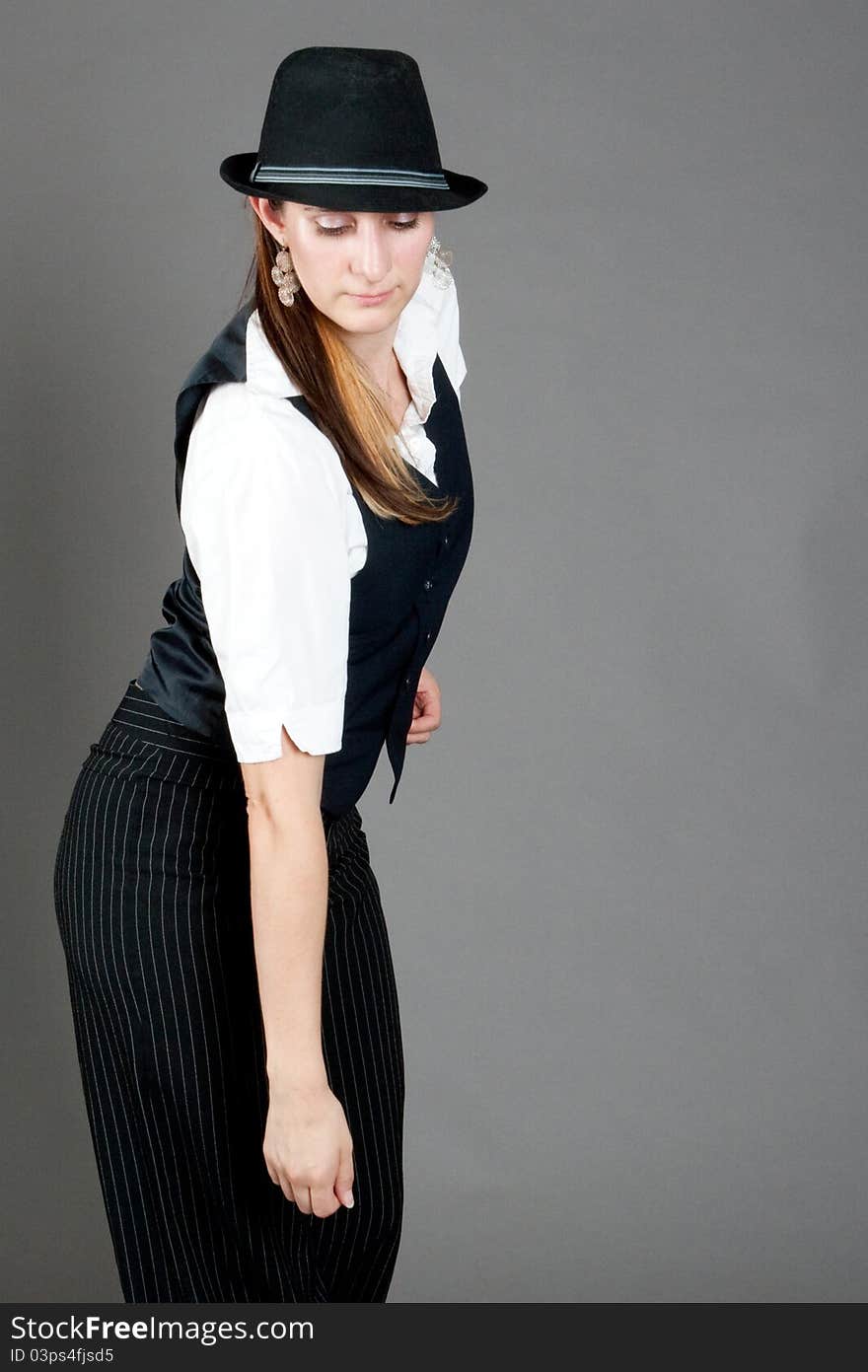 Caucasian female jazz dancer poses in front of a studio gray backdrop.