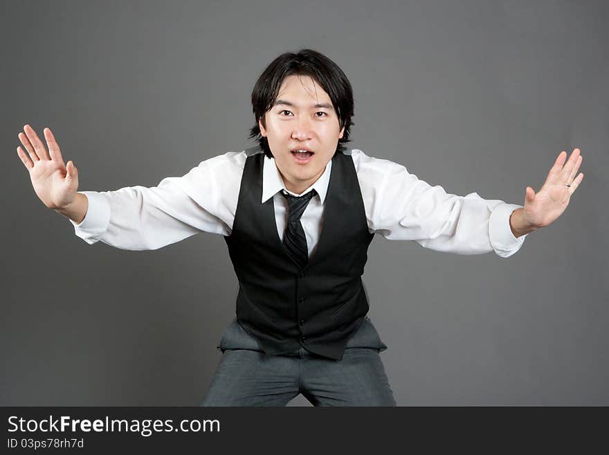 Asian male jazz dancer poses in front of studio gray backdrop.