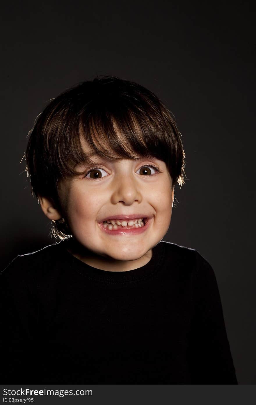 Child portrait close up over black bg