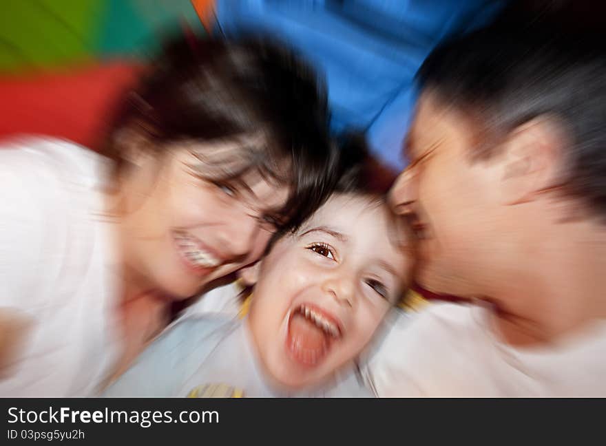 Happy family close up posing on colorful bed. Happy family close up posing on colorful bed