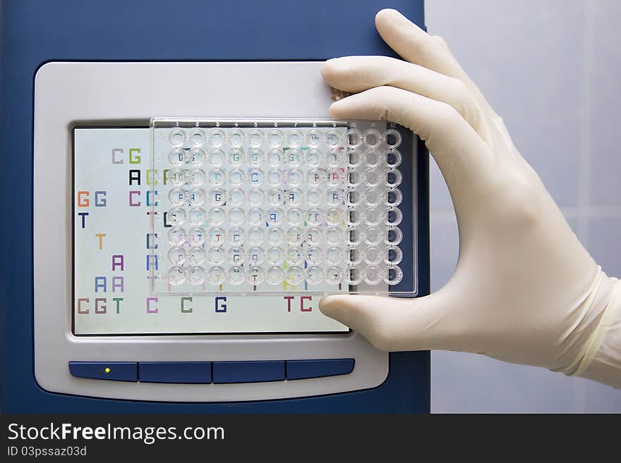 Well plate in front of screen of real-time pcr machine. Well plate in front of screen of real-time pcr machine