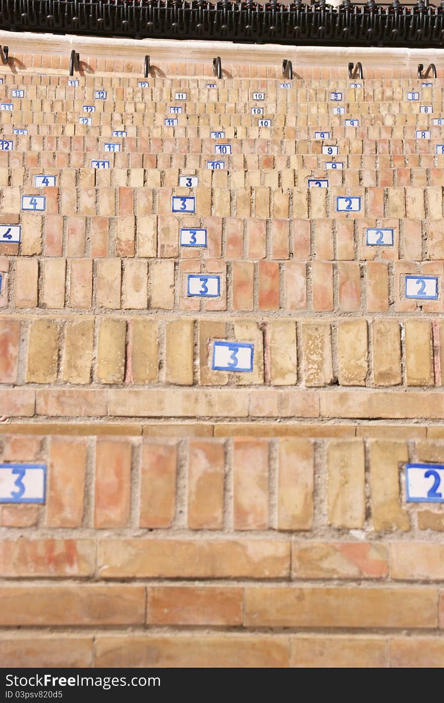 Bullring seats with small numbered tiles. Selective focus, shallow DOF.