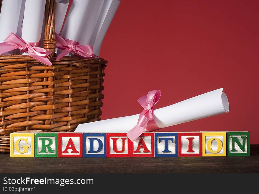 Diploma tied with a ribbon, the text of the wooden blocks Graduation.