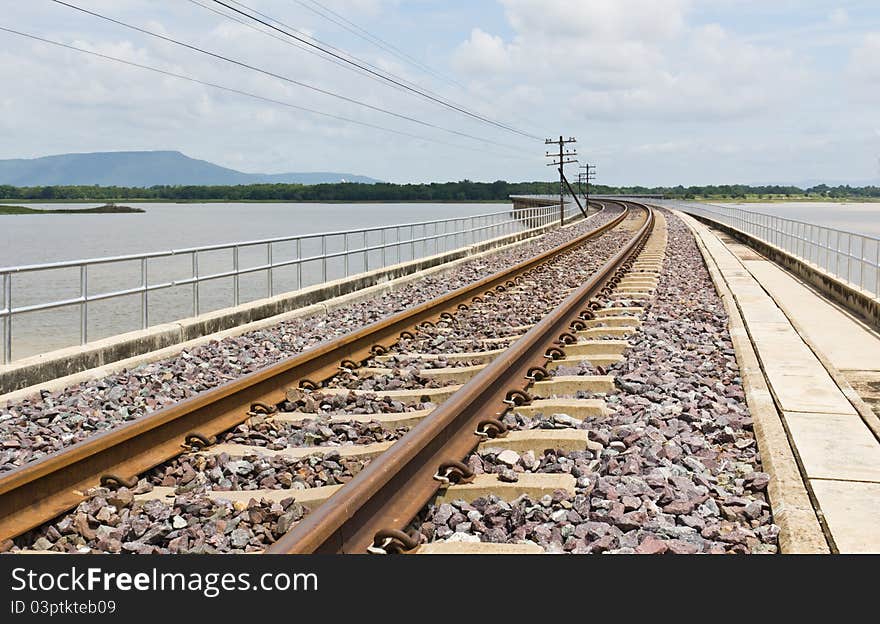 Railroad tracks curving across the lake