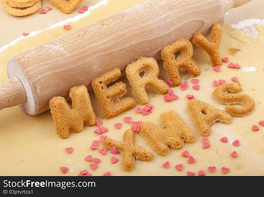 Studio-shot of preparing and baking cookies for christmas. baked letter biscuits spelling out the word merry xmas. Studio-shot of preparing and baking cookies for christmas. baked letter biscuits spelling out the word merry xmas.